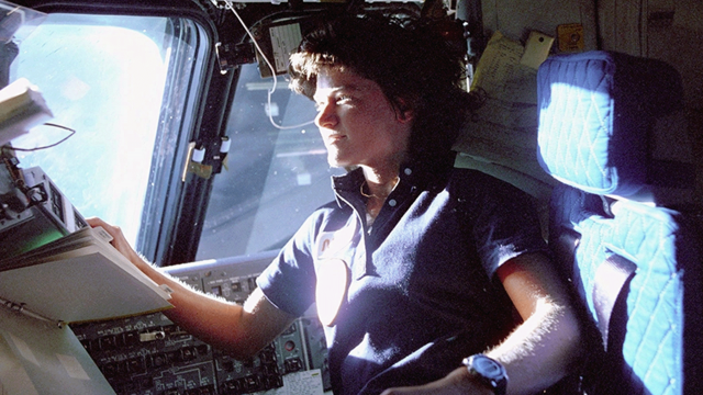 Sally Ride was a mission specialist on STS-7. In this image, she monitors control panels from the pilot's chair on the flight deck.